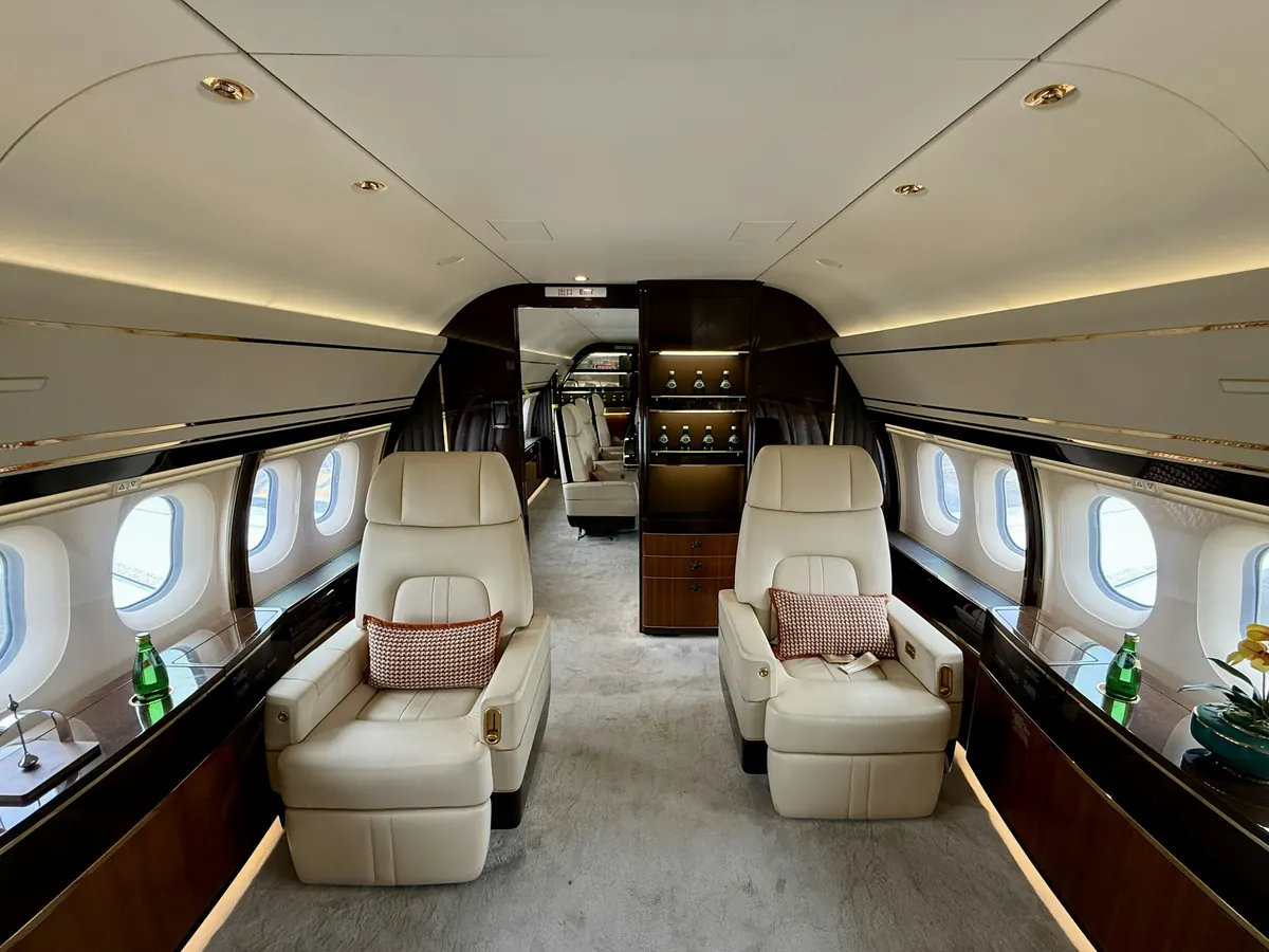 Wide cabin of a large jet with cream club seats