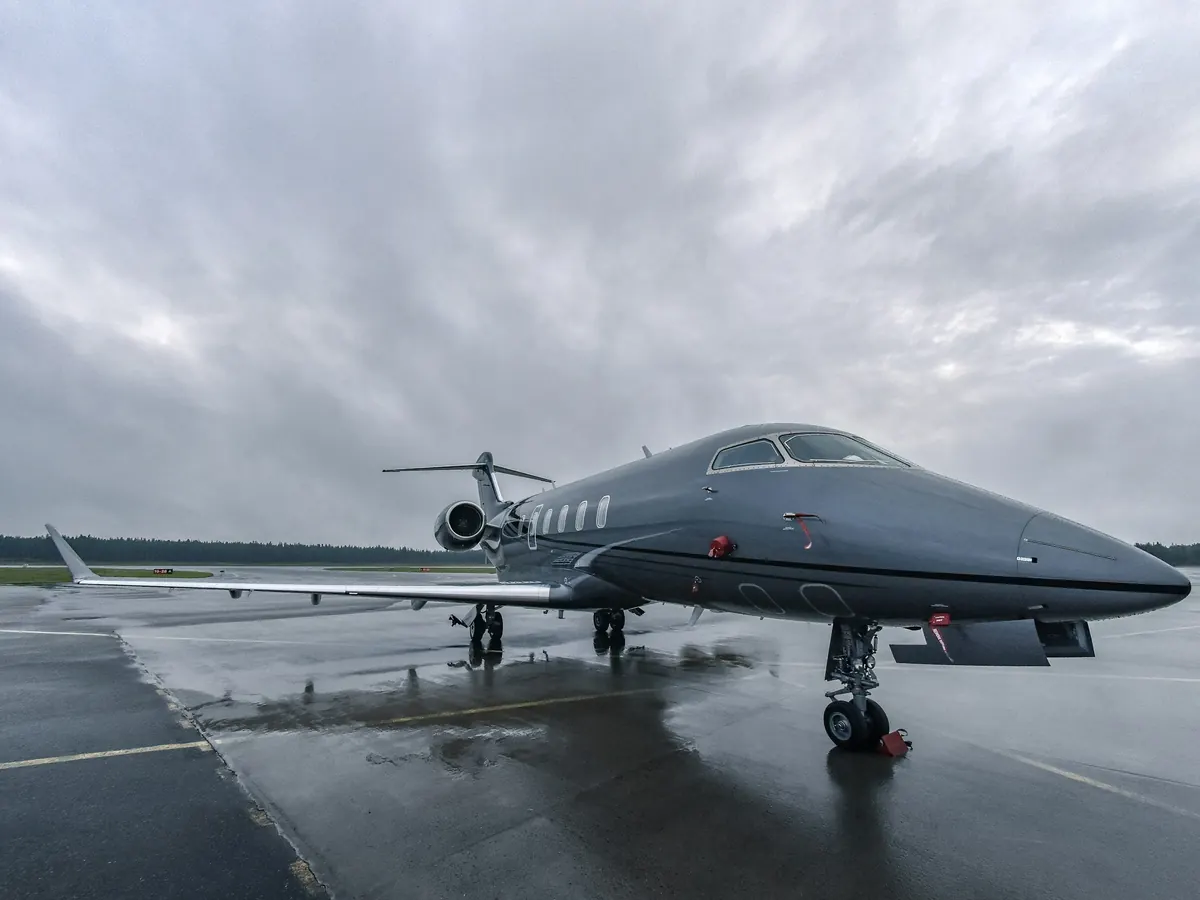 Long-range jet on a wet ramp under grey skies