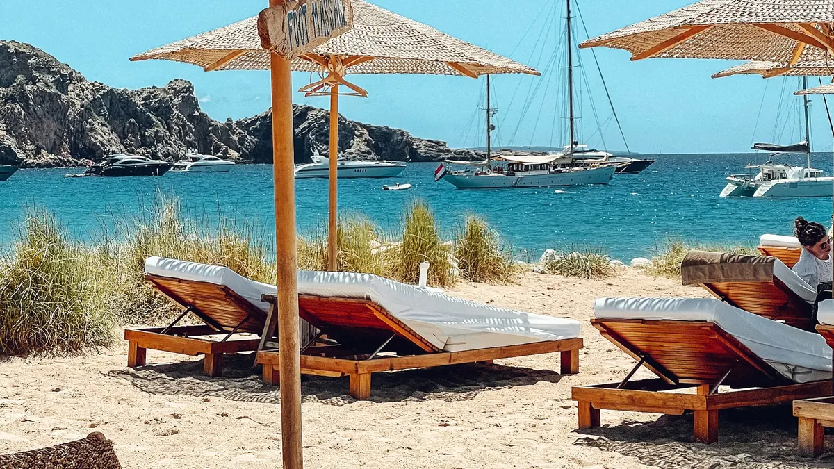 Empty sun loungers under parasols at a beach club
