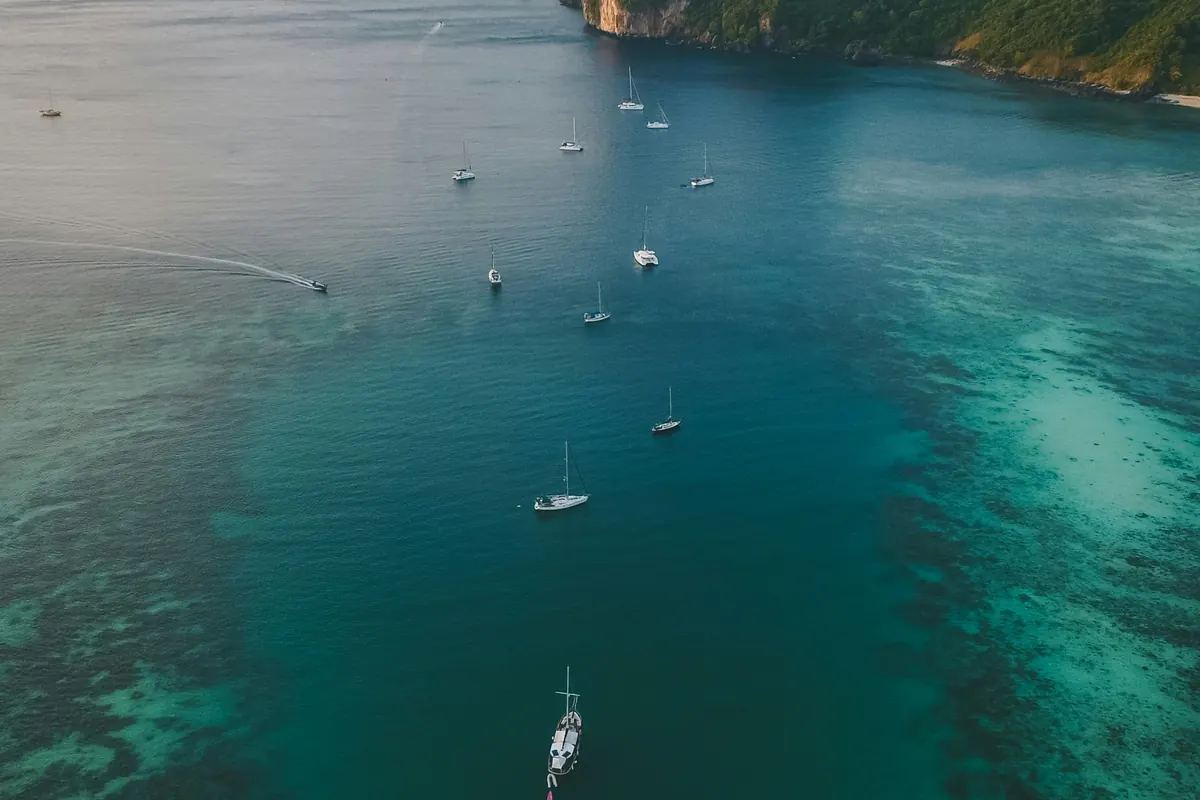 Boats anchored in a turquoise bay seen from above